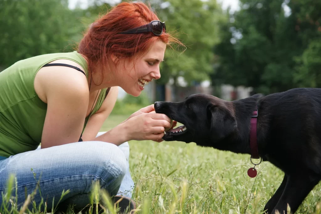 Woman playing with black dog
