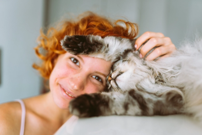 Woman leaning against cat. Signs your cat loves you.